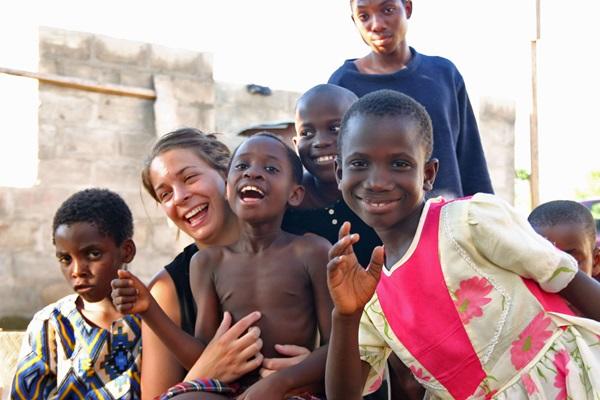 Volunteer with Children at Care Center in Ghana A volunteer laughing with a group of children at a Childcare placement in Ghana
