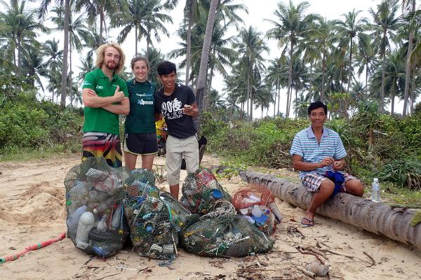 Projects Abroad staff and volunteers collect waste on a beach in Cambodia at the Diving & Marine Conservation Project.