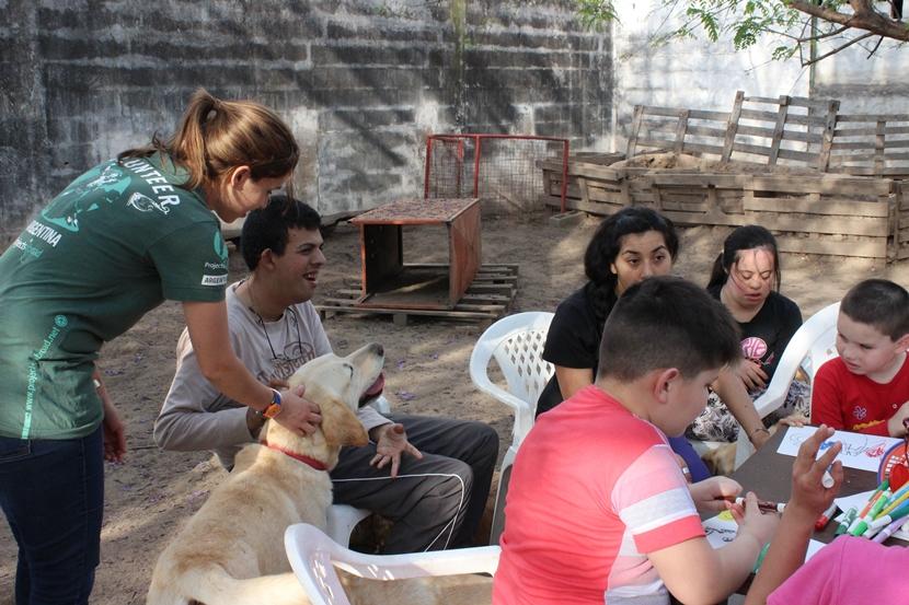 A Projects Abroad volunteer helps a disabled young man interact with a trained therapy dog in Argentina. A Projects Abroad volunteer helps a disabled young man interact with a trained therapy dog in Argentina.