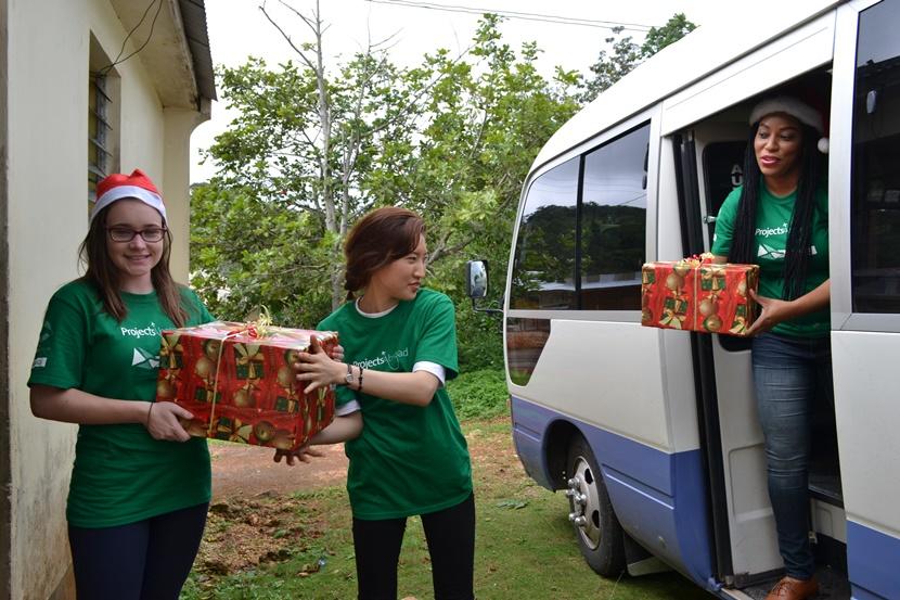 Care volunteers unload a van full of Christmas gifts for children in Jamaica Volunteers unpack a van full of Christmas presents during their Care placement in Jamaica
