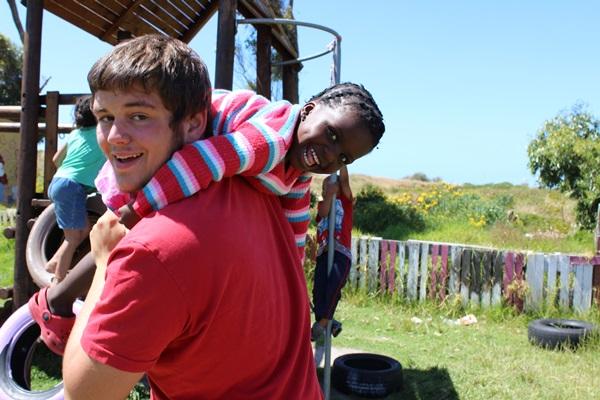 Volunteer having fun with a child in a care project in South Africa Male volunteer with a child in South Africa.