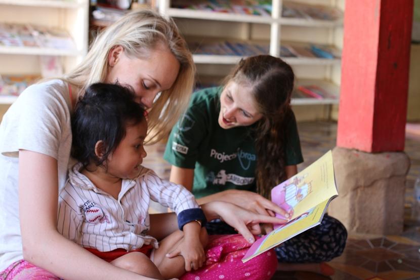 Care and Community volunteers enjoy a reading activity with the children in Cambodia Projects Abroad Care and Community volunteer reads to the children at her placement in Cambodia