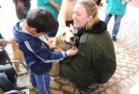 Care A volunteer helps a child interact with a dog at the Canine Therapy Project in Bolivia.