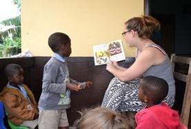 Care A volunteer reads a story to children in Ghana.
