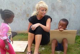 Culture & Community A volunteer assists young Jamaican children with their homework on the Maroon Community Project.