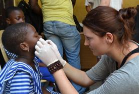 Electives for Medical<br /> Students A volunteer examines a child's gums and teeth as part of her Dentistry School Elective in Ghana.