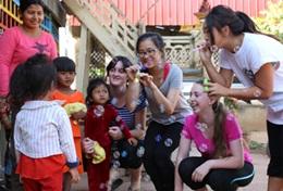 Cambodia High School Special students on their Care & Community Project in Cambodia play a game with young children.