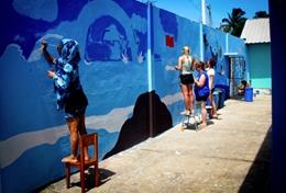 Ecuador High School Special volunteers in Ecuador paint a school wall as part of their Care & Community Project.