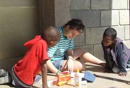 Ethiopia A Care & Community High School Special volunteer in Ethiopia works on a craft activity with young children.