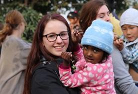 Nepal A Care & Community High School Special volunteer in Nepal holds a child at her placement.
