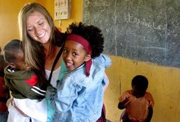 Tanzania A volunteer hugs children on her Care & Community High School Special in Tanzania.