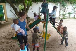 Togo A volunteer on the Togo Care & Community High School Special plays with children on the playground.
