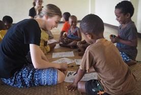 Fiji A Care & Community Village Project High School Special volunteer colours in a picture with a young boy in Fiji.