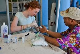 Philippines A Public Health High School Special Phulippines volunteer checks a man's vital signs.