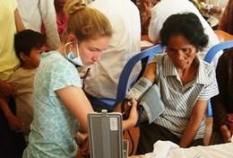 Cambodia A High School Special student in Cambodia checks a woman's blood pressure on the Public Health Project.