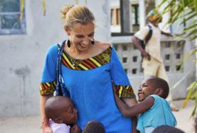 Volunteer in Childcare at a Care Center in Africa Volunteer on a Care project plays outside with children in Africa