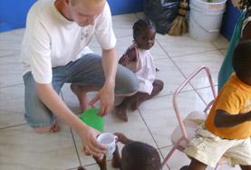 Medicine & Healthcare A dental intern in Jamaica gives a child water to rinse her mouth as part of a dental outreach.