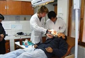 Peru A dental intern in Peru helps a professional dentist during a procedure.