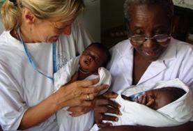 Medicine & Healthcare A volunteer and local midwife hold newborn babies in Ghana, Africa.