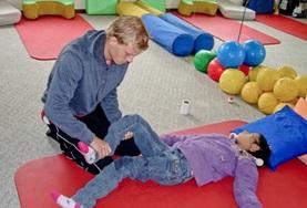 Medicine & Healthcare A volunteer helps a young boy with his leg on the Bolivia Physical Therapy Internship.