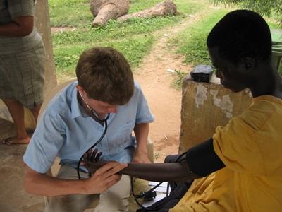 Treating Adults in Medical Outreach Programs on the Public Health Project in Ghana Intern on the Public Health project checks the heart rate of an older woman in Ghana