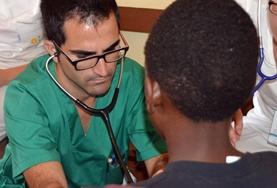 Medicine & Healthcare Based in Jamaica, a volunteer doctor takes a photo with his patients at his placement.