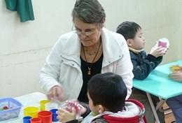 Vietnam Based in Vietnam, a professional occupational therapist assists a young child during a therapy session.