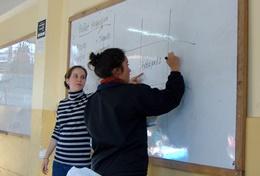 Teaching A professional teacher volunteering in Peru helps a student solve a math problem during class.