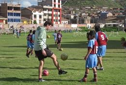 Sports A child practices soccer drills with the help of a volunteer in Peru.