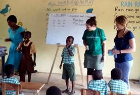 Teaching A volunteer helps a student complete an exercise during class in Ghana.